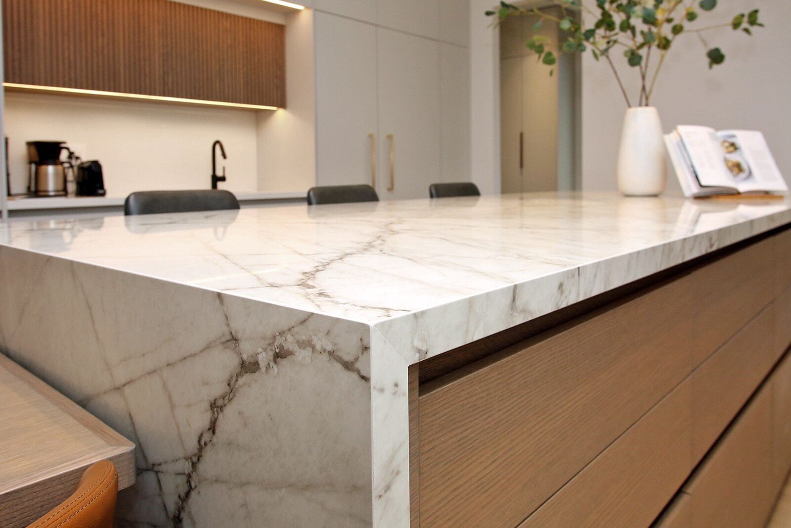 Warm wood kitchen island with a marble waterfall edge, Casa Marbella renovation in Alderwood