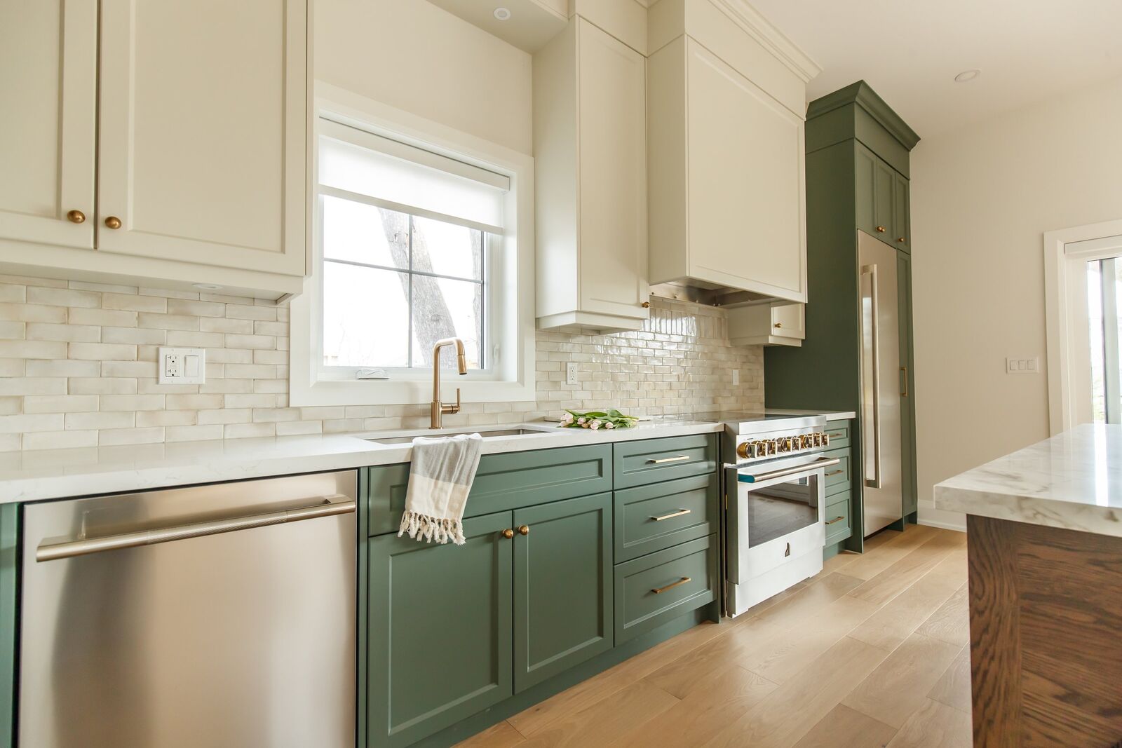 Deep green kitchen cabinetry with marble counters, Evergreen Elegance renovation in Alderwood